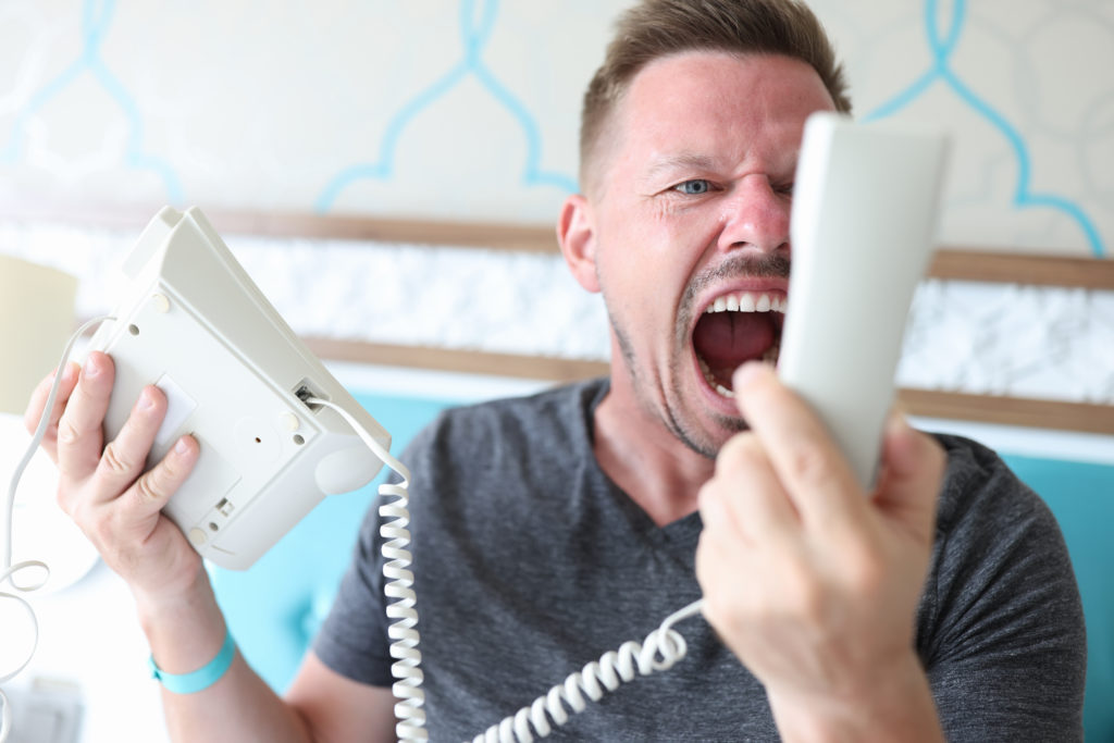 robocalls image of a frustrated man yelling into his telephone